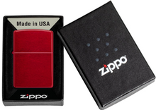 Load image into Gallery viewer, A red Zippo lighter displayed next to its black presentation box, with the lid showing the white Zippo logo and the open box showing the lighter inside.

